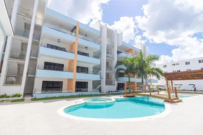 an apartment building with a swimming pool in front of it at Cozy 1-BR Apartment in Sunshine Bayahibe in San Rafael del Yuma