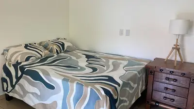 a bedroom with a bed and a lamp and a dresser at Guest House Canephora in Las Galeras in Las Galeras