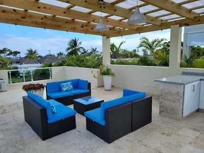 a patio with blue chairs and a table and a counter at Villa Serenity In The Sun in Sosúa