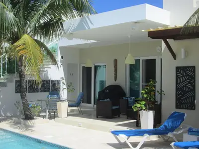 a villa with a swimming pool and a house at Villa Serenity In The Sun in Sosúa