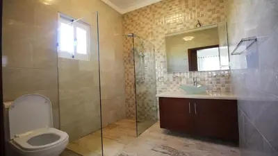 a bathroom with a toilet and a sink and a mirror at Villa Serenity In The Sun in Sosúa