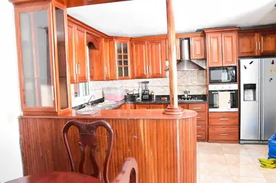 a kitchen with wood cabinets and a wooden counter top at Yolanda's house in Bayaguana