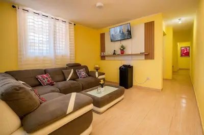 a living room with a brown couch and a tv at Beautiful Caribbean Coast Residence in Santo Domingo