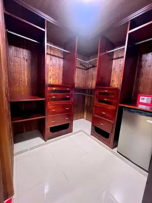 a walk in closet with wooden cabinets at Beautiful Caribbean Coast Residence in Santo Domingo
