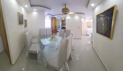 a dining room with a white table and chairs at Apartamento in Santo Domingo