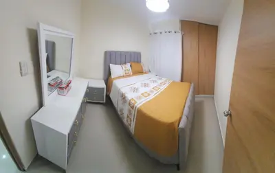 a small bedroom with a bed and a mirror at Apartamento in Santo Domingo