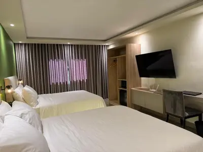 a hotel room with two beds and a flat screen tv at Caonabo35 Elegancia Boutique en Santo Domingo1 in Santo Domingo