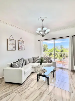 a living room with a white couch and a table at Beautiful and confortable apt in Puerto Plata