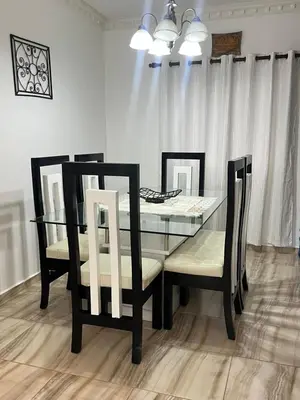 a dining room table with two chairs and a glass table at Beautiful and confortable apt in Puerto Plata