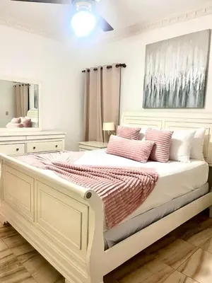 a bedroom with a large white bed with pink pillows at Beautiful and confortable apt in Puerto Plata