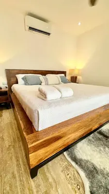 a bedroom with a large wooden bed with white sheets at Casa Las Ballenas - 3 bedroom Las Terrenas in Las Terrenas