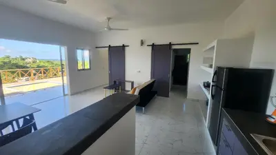 a kitchen and living room with a view of a balcony at Endless Horizon Apartments in Las Terrenas