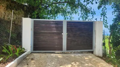 a gate with a wooden door in a fence at Endless Horizon Apartments in Las Terrenas