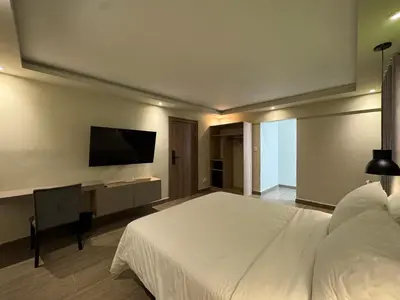 a bedroom with a white bed and a flat screen tv at Caonabo35 Elegancia Boutique en Santo Domingo 6 in Santo Domingo