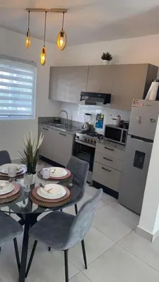 a kitchen with a table and chairs and a refrigerator at WRparaiso in Cuevas