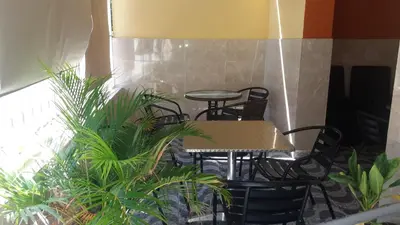 a table and chairs in a room with plants at Hotel Gazcue in Santo Domingo
