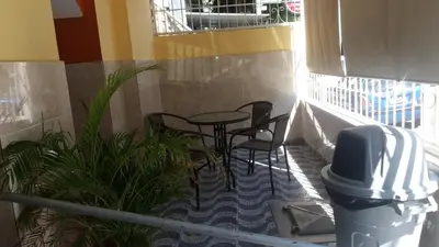 a patio with chairs and a table and plants at Hotel Gazcue in Santo Domingo
