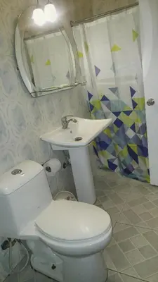 a bathroom with a toilet and a sink and a mirror at Hotel Gazcue in Santo Domingo