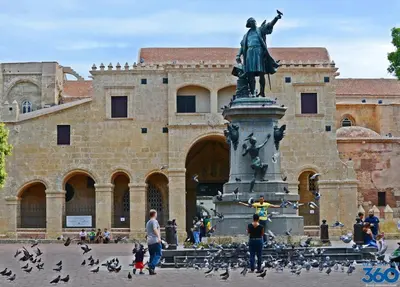 a statue in front of a building with a flock of birds at Hotel Gazcue in Santo Domingo