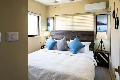 a bedroom with a large white bed with blue pillows at Newly built 2 bedroom 2 bath private pool villa! in Sosúa