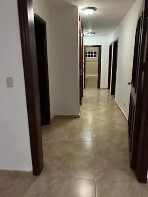 a hallway with white walls and tile floors and doors at Villas Burnette in Camú