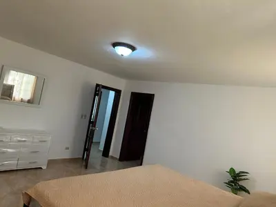 a bedroom with a bed and a dresser and a light at Villas Burnette in Camú