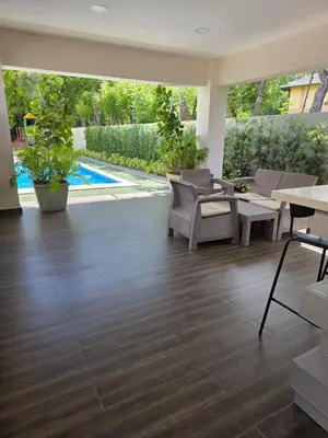 a living room with a wooden floor and a pool at La Elegancia in Canabacoa