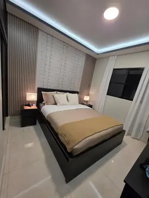 a bedroom with a large bed with two lamps on it at La Elegancia in Canabacoa