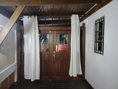 a wooden door with curtains in a room at Apartamento Confortable Moderno Minimalista in Ciruelitos Arriba