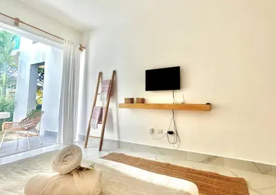a living room with a flat screen tv on a wall at Beachside Studio with Pool, Steps to Playa Bonita in Las Terrenas