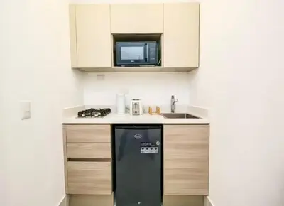 a small kitchen with a black refrigerator and a microwave at Beachside Studio with Pool, Steps to Playa Bonita in Las Terrenas