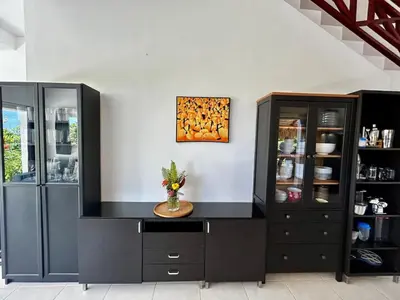 a kitchen with black cabinets and a painting on the wall at Hilltop Dominican Villa with Pool and Big Terrace in Las Terrenas