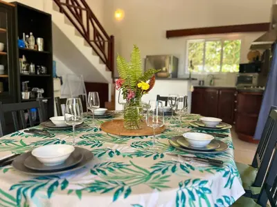 a table with plates and glasses and a vase with flowers at Hilltop Dominican Villa with Pool and Big Terrace in Las Terrenas