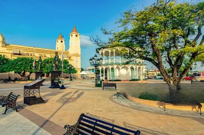 a park with benches in front of a building at Space Freedom Connection in Sosúa