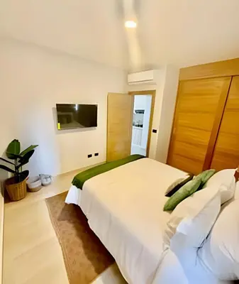 a bedroom with a large bed and a flat screen tv at Garden Breeze 1 By Advantage Club