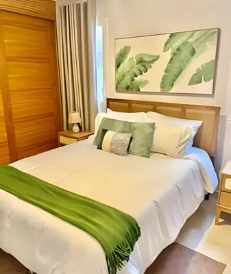 a bedroom with a large white bed with green pillows at Garden Breeze 1 By Advantage Club