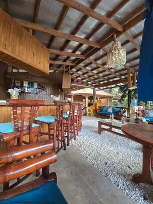a restaurant with wooden tables and chairs and a chandelier at Villa Doña Macha