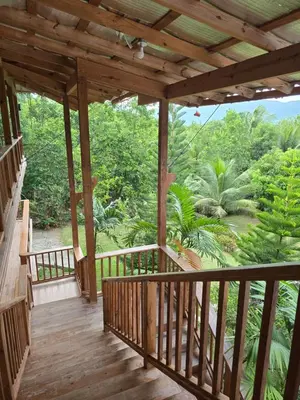 a wooden porch with a view of a forest at Villa Doña Macha