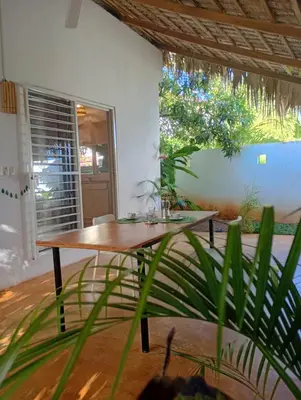a wooden table in a room with a plant at Quédate Aquí También in Las Galeras