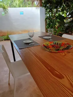 a wooden table with two wine glasses on it at Quédate Aquí También in Las Galeras