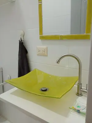 a yellow sink sitting on a counter in a bathroom at Quédate Aquí También in Las Galeras