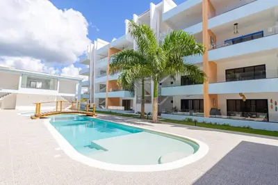 a swimming pool in front of a building at Caribbean Pearl 2BR Sunshine Bayahíbe in Bayahibe