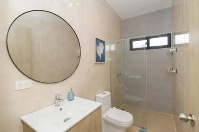 a bathroom with a sink and a toilet and a mirror at Caribbean Pearl 2BR Sunshine Bayahíbe in Bayahibe