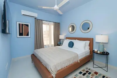 a blue bedroom with a bed and a ceiling fan at Caribbean Pearl 2BR Sunshine Bayahíbe in Bayahibe