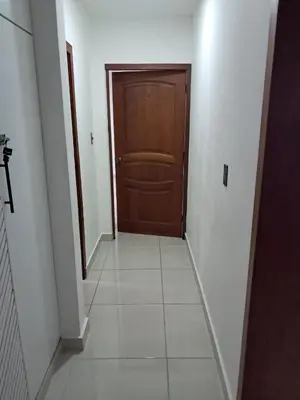 a hallway with a wooden door and a tile floor at Torre san geronimo 1109 apartamento 10-06 in Santo Domingo