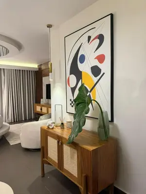 a living room with a table with a painting on the wall at Villa Paraíso Casa de Campo in La Romana