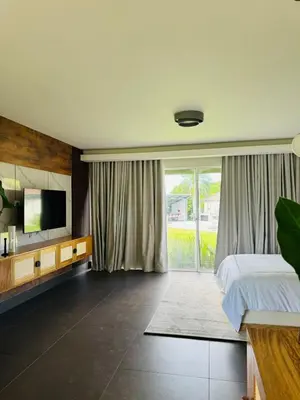 a bedroom with a bed and a tv on a wall at Villa Paraíso Casa de Campo in La Romana