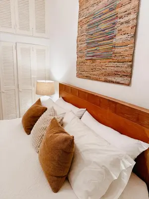 a bedroom with a bed with white sheets and pillows at Lux Villa Casa de Campo in La Romana