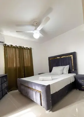 a bedroom with a large bed with a ceiling fan at Apartment near the airport in Boca Chica