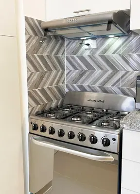 a stainless steel stove in a kitchen with tiles at Apartment near the airport in Boca Chica